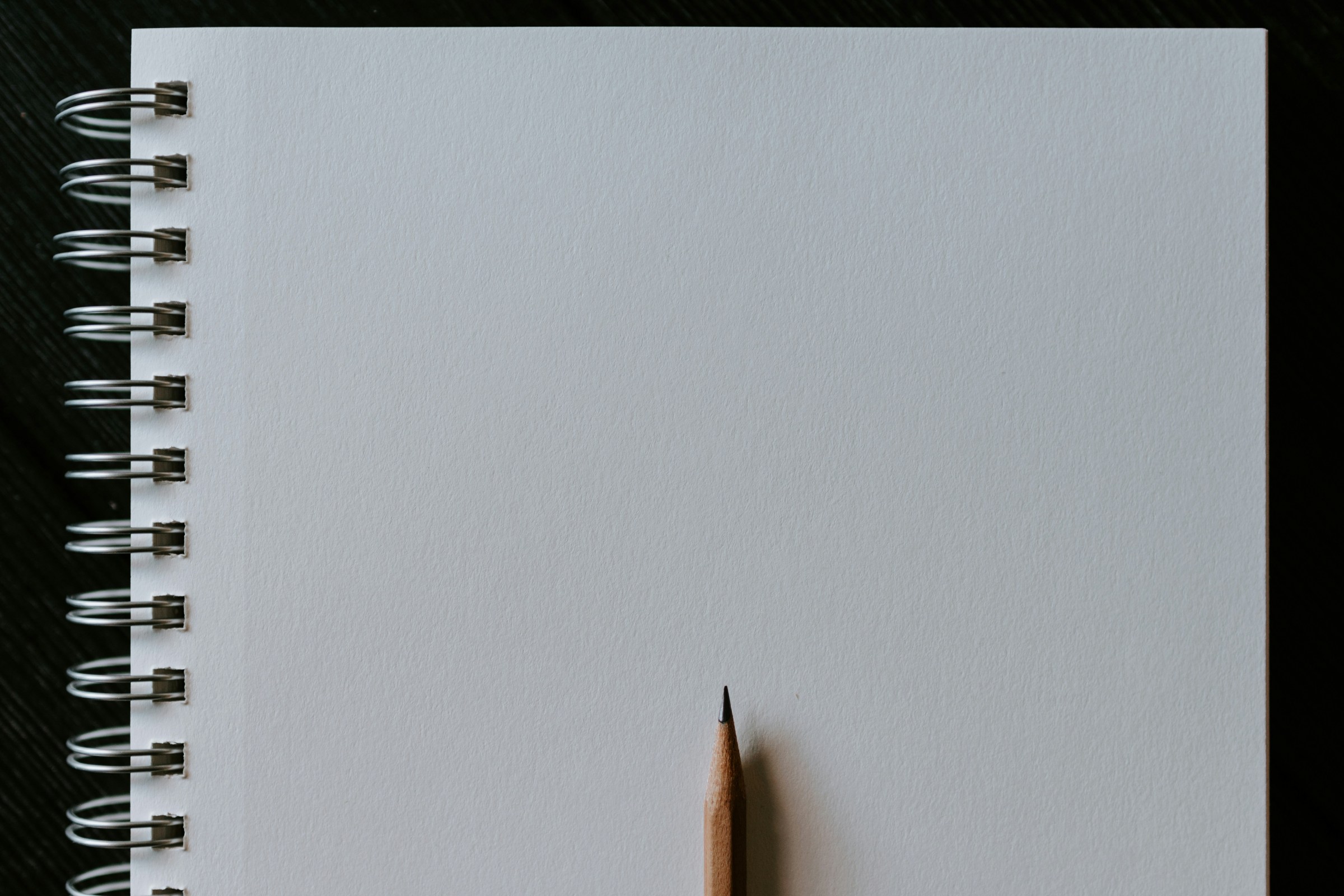 A blank piece of paper with a sharpened pencil
